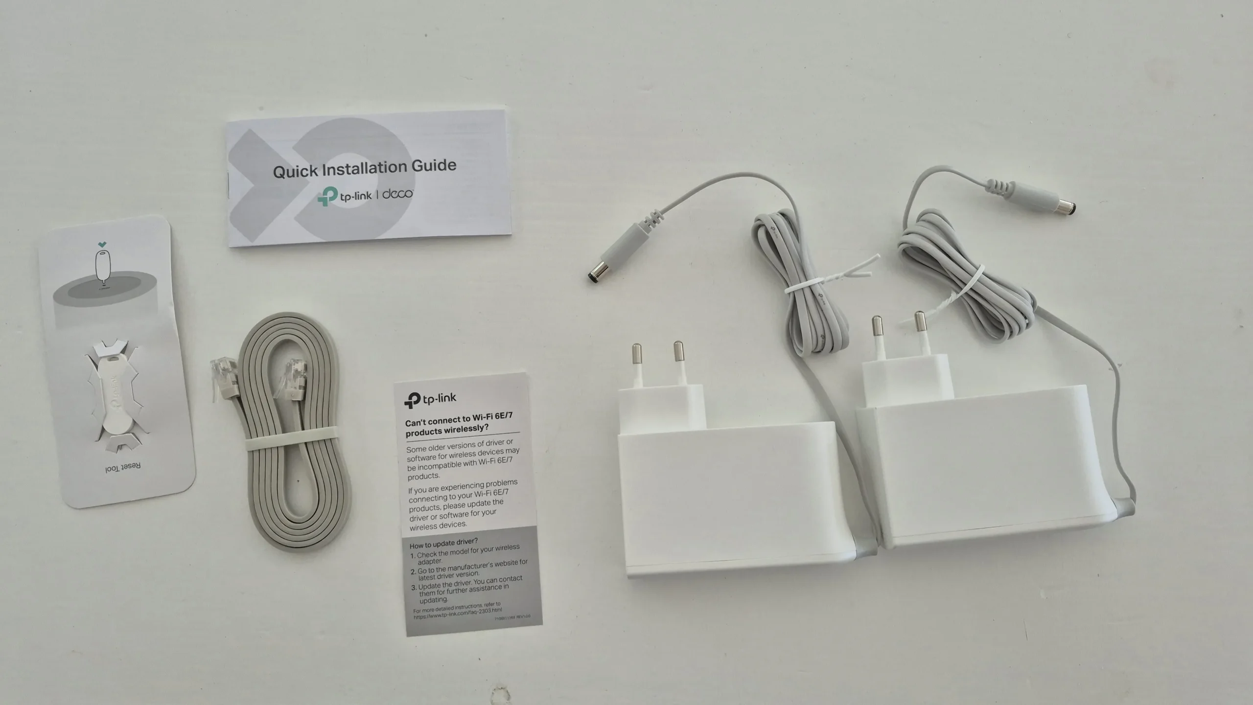 The included power adapters, Ethernet cable and printed setup material.